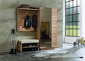Vorraum mit Garderobe aus Holz und integriertem Spiegel sowie Sitzbank mit beigem Lederbezug