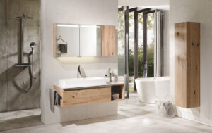 Helles Badezimmer mit Spiegel und Waschbecken in weiß mit Ablagefläche aus Holz, sowie freistehender Badewanne und Walk-In Dusche