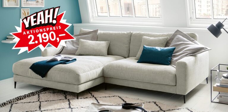 Helles Sofa mit Cord-Bezug im modernen Wohnzimmer mit Kissen und Teppich, Aktionspreis 2.190 €.