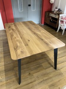 großer Holztisch mit schwarzen Tischbeinen