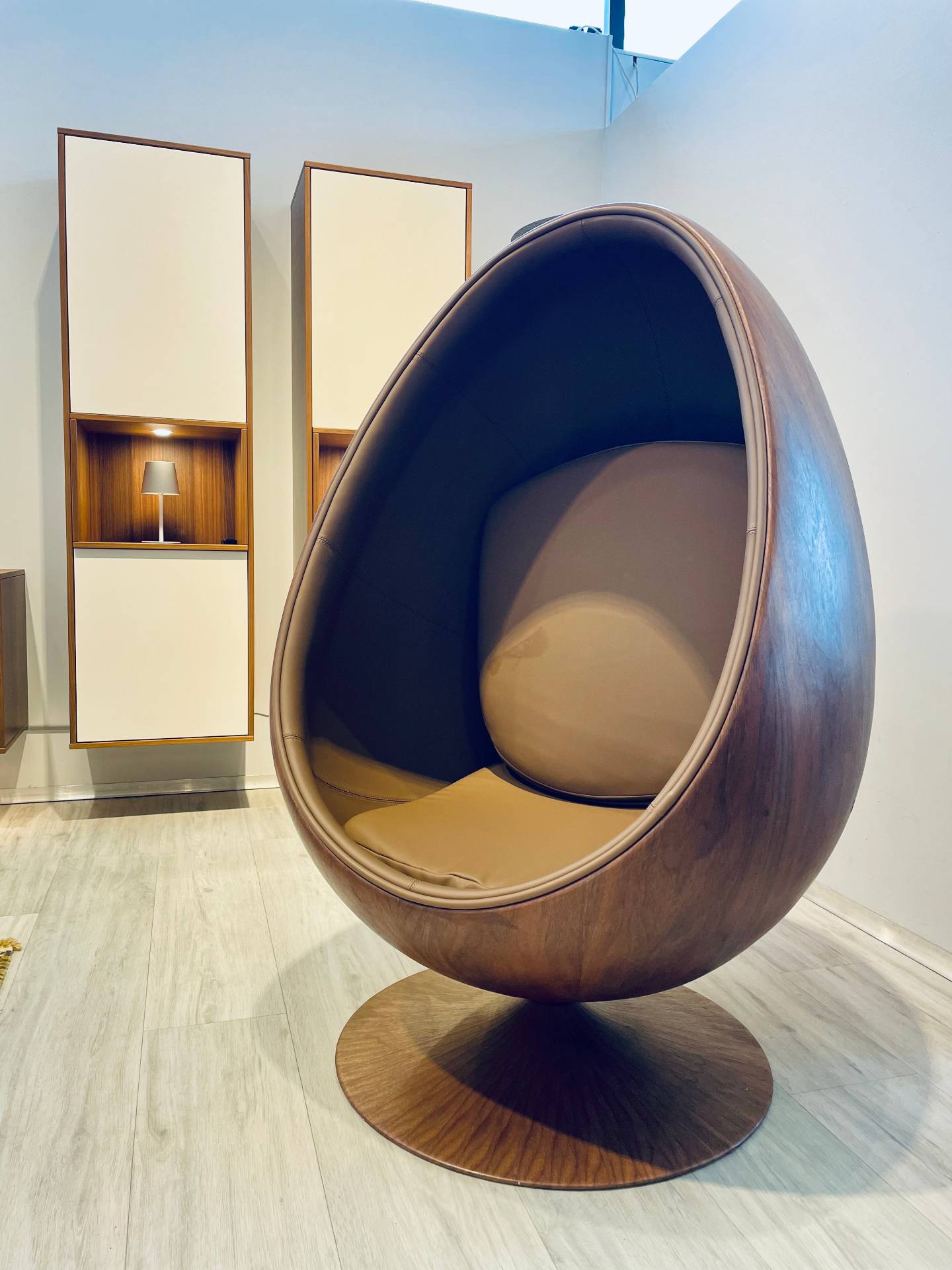 Gemuetlicher Sessel bei Möbel Polt: Eiförmiger Design-Stuhl in Holzoptik mit brauner Polsterung als Wohntrend 2026.