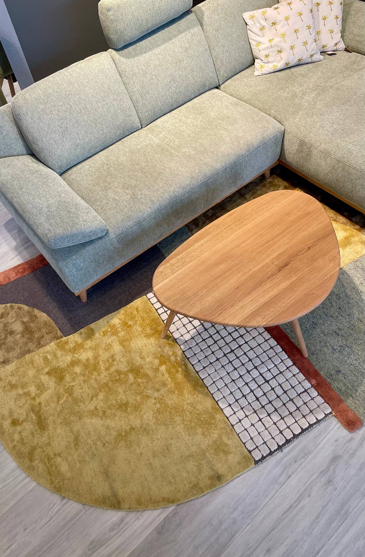 Hellgrüne Polstermöbel mit Holz-Couchtisch auf buntem Teppich, aktuelle Wohntrends 2026 von Möbel Polt.