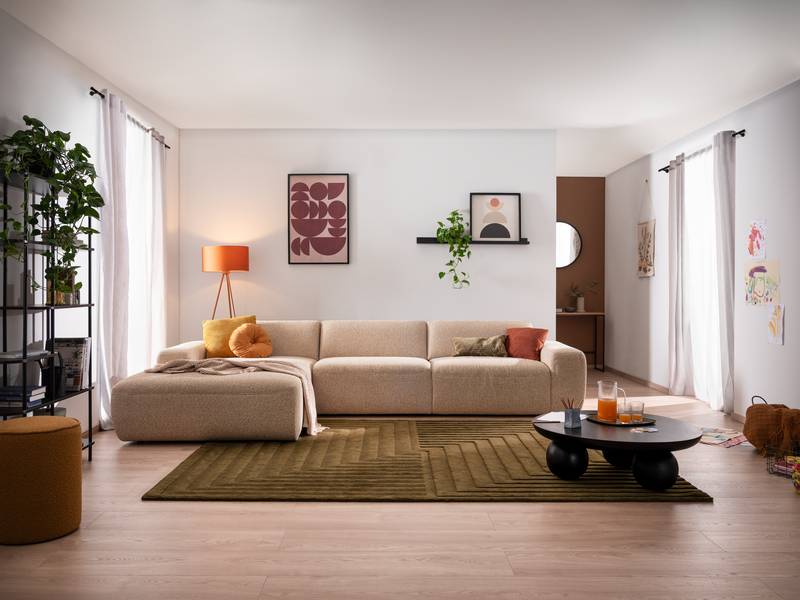 Modernes Wohnzimmer mit beige Polstermöbeln, grünem Teppich und Wohntrends 2026 von Möbel Pölt.